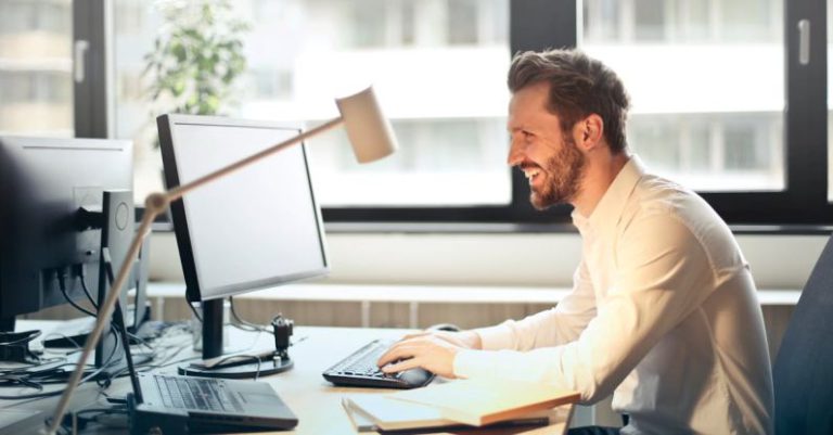 Email - Man in White Dress Shirt Sitting on Black Rolling Chair While Facing Black Computer Set and Smiling