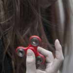 Trends - Woman Holding Red Hand Spinner