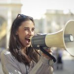 Content - Cheerful young woman screaming into megaphone