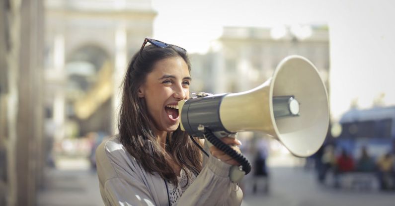 Content - Cheerful young woman screaming into megaphone