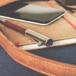 Content - Smartphone Displaying Black Screen on Notebook Beside Pen and Sunglasses