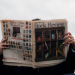 Reviews - Person Holding White and Brown Newspaper